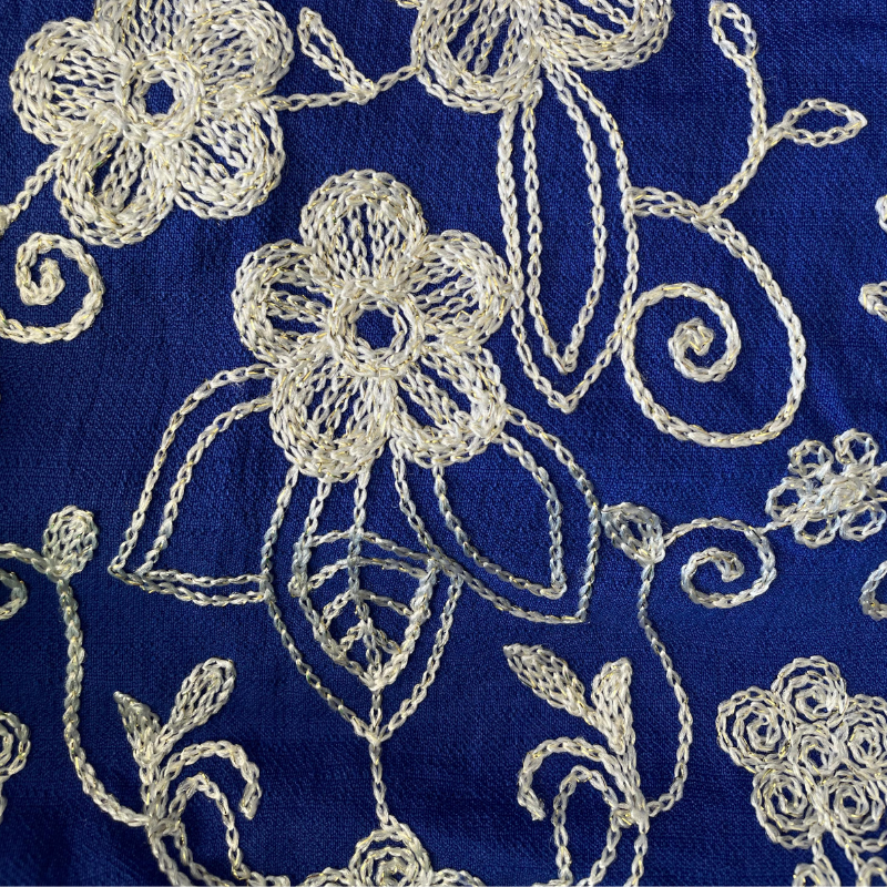 Detalhe do bordado floral com leve brilho em vestido azul royal